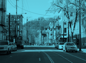 Streetscape with cars and trees, blue tint