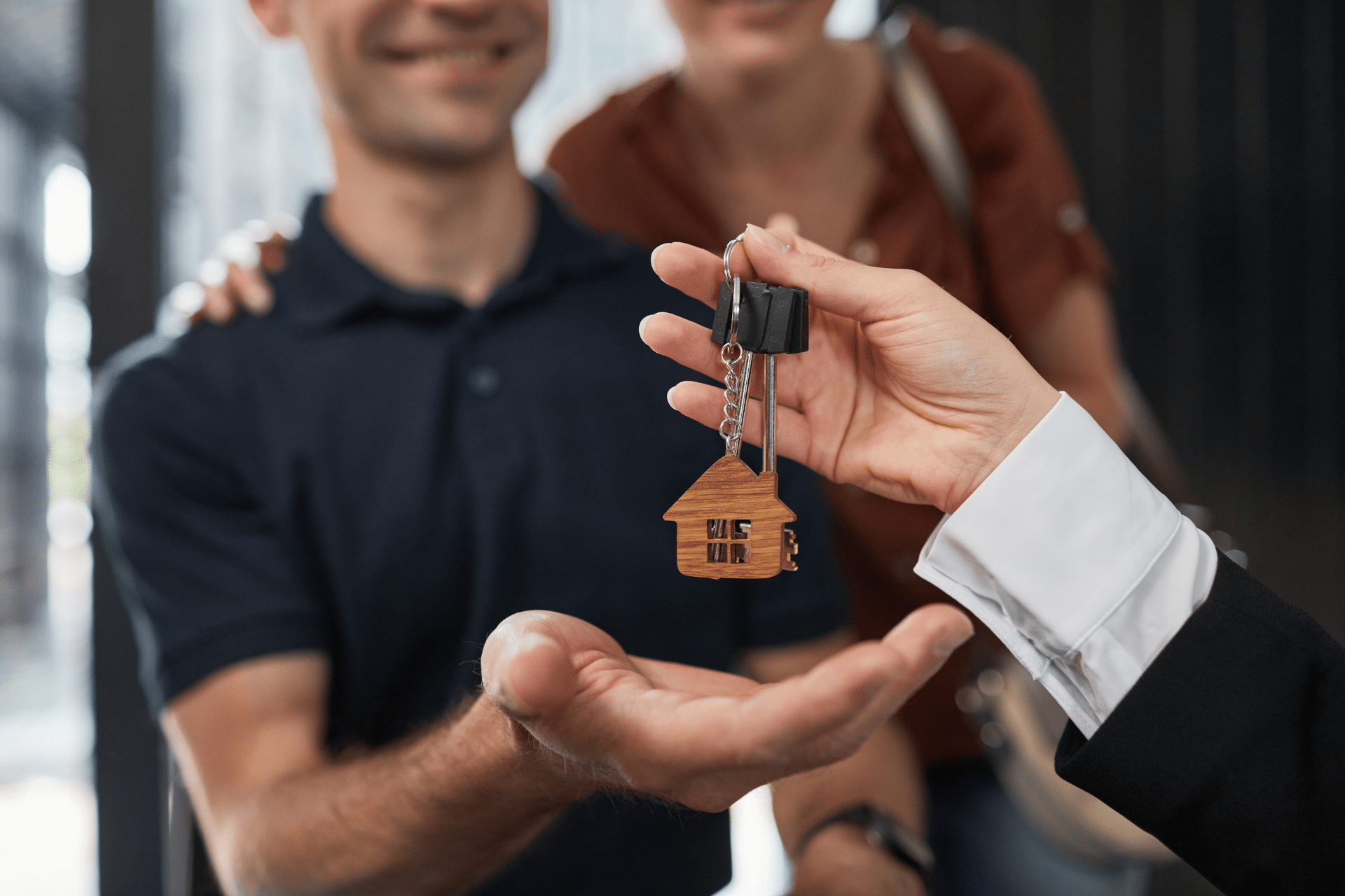 Image of a man receiving a house key illustrates how CLTS can support immigrant housing