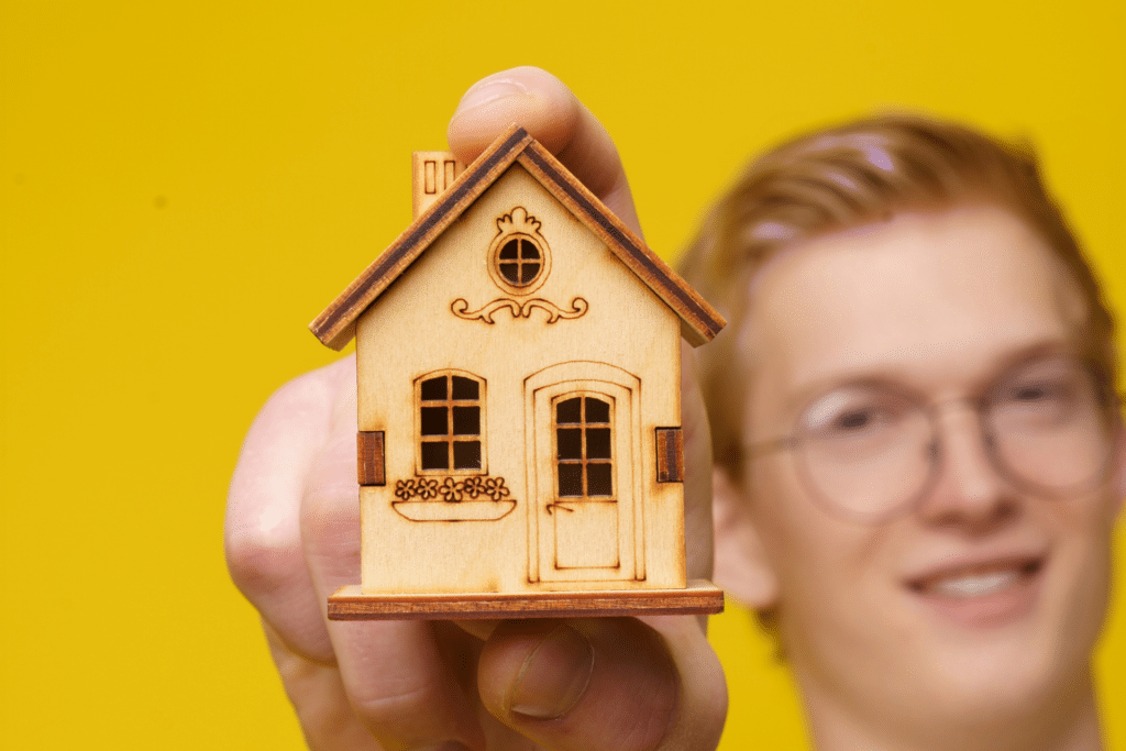 An image of a young person holding a house is shown to illustrate homeless youth research in rural Missouri