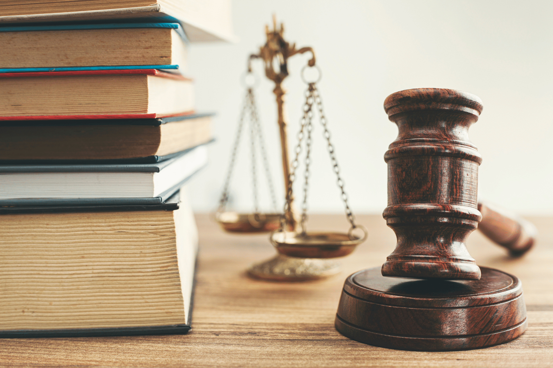 Image is of a gavel and a scale of justice and some books to illustrate the concept of criminal justice and housing and breaking the cycle of homelessness and incarceration