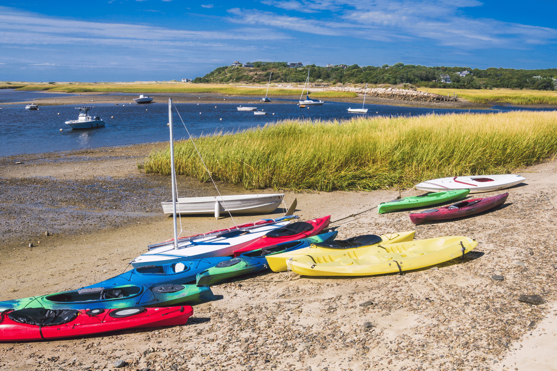 Kayaks on a beach in Cape Cod are shown. Cape Cod is a popular seasonal town during the summer months.