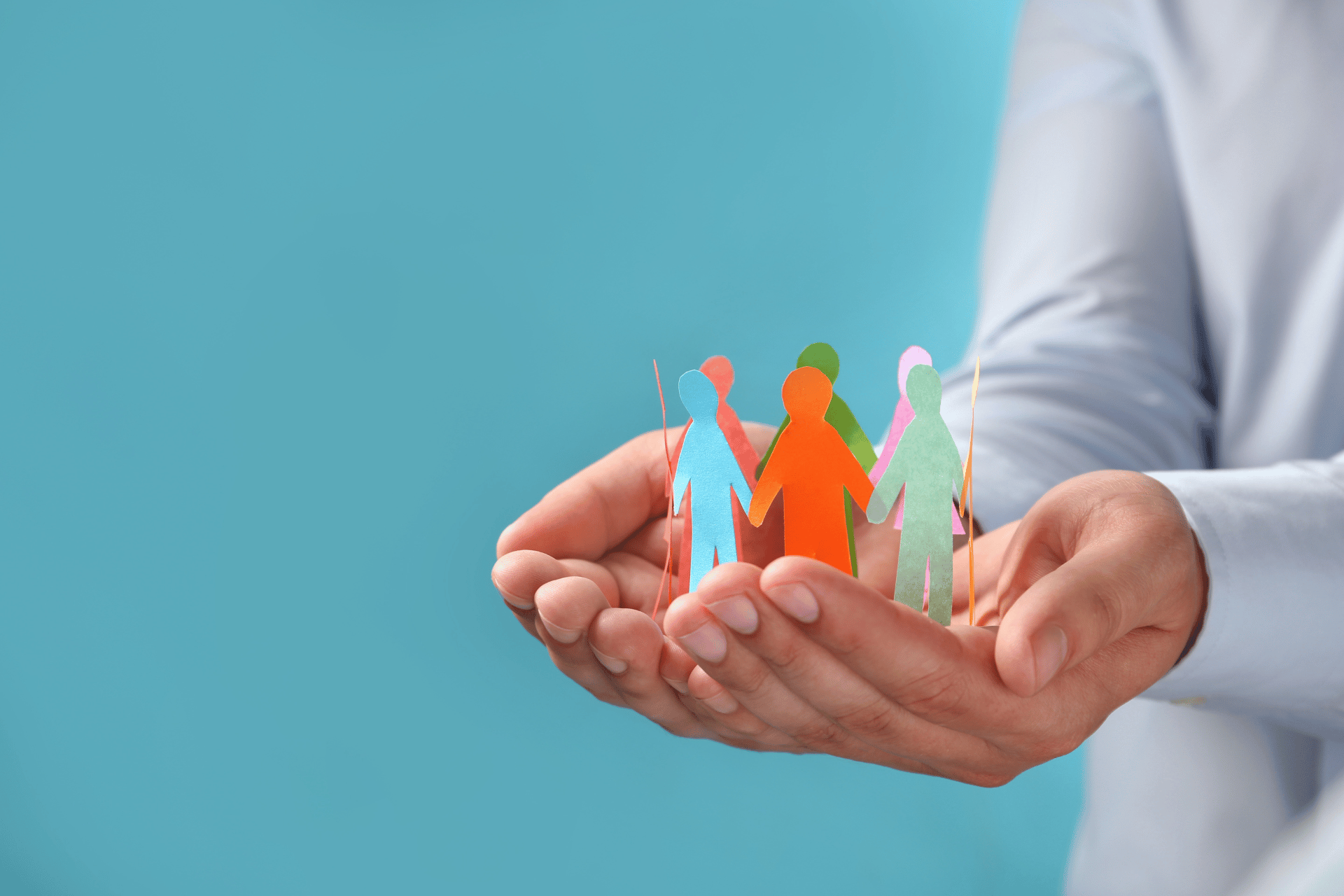 Hands holding paper figures in different colors is used to illustrate the concept of equity and equity in housing.